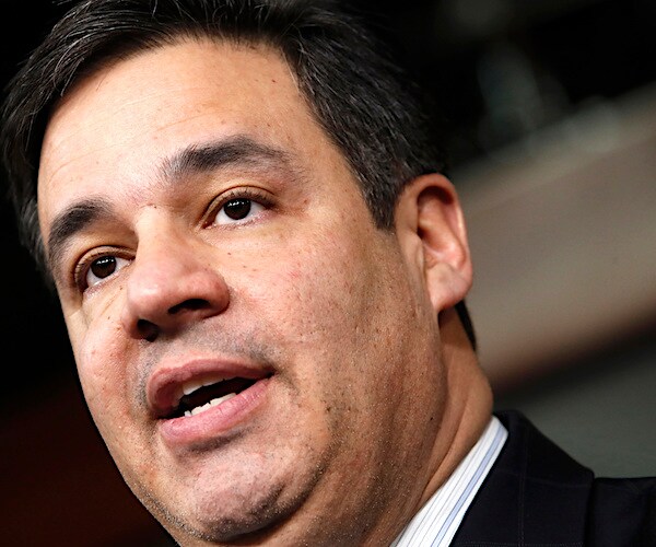 idaho republican representative tilts his head slightly to his right, while looking left and delivering his remarks