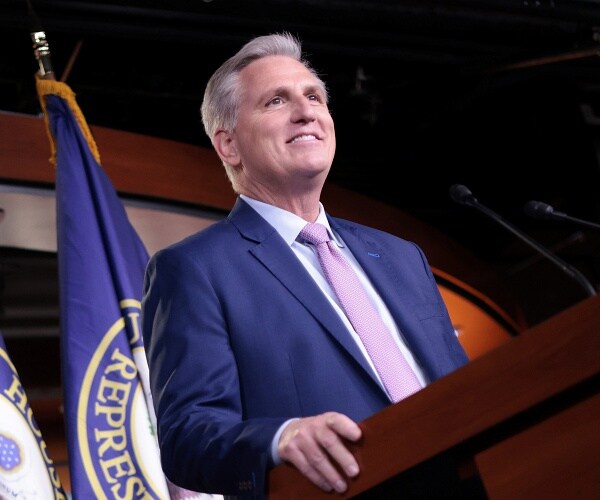 kevin mccarthy smiles while standing behind podium