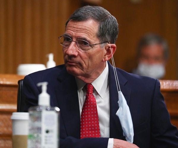 john barrasso sits at a table with his face mask lowered