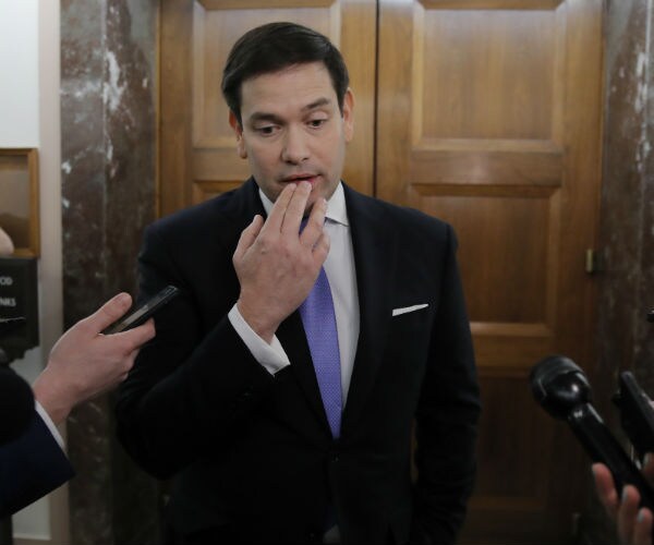 Sen. Marco Rubio, R-Fla., touches his mouth as he speaks to media on Capitol Hill 
