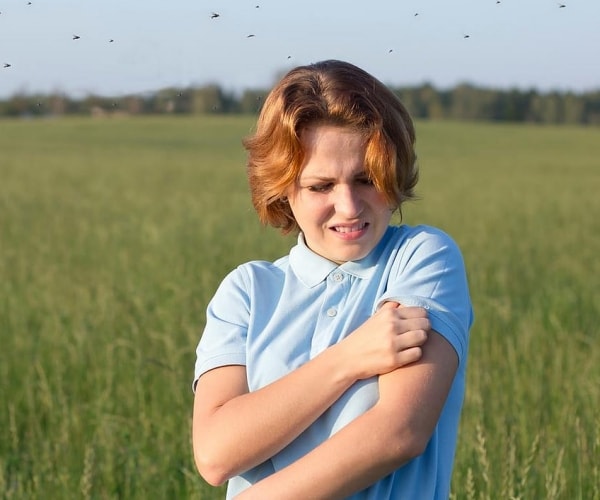 a boy scratching his arm