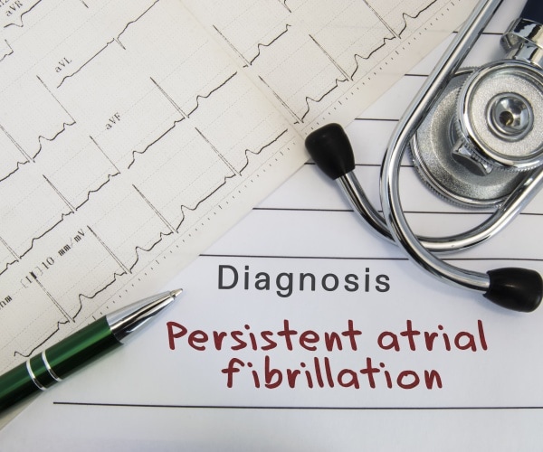 diagnosis pad saying 'persistent atrial fibrillation', an ekg, stethoscope
