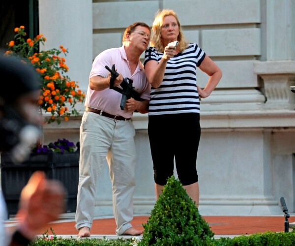 mccloskeys stand outside their house holding guns