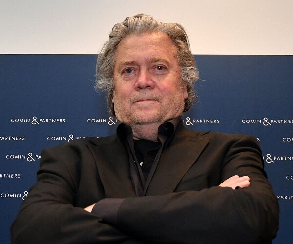 steve bannon stands with arms crossed