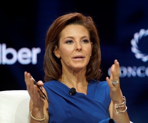 ruhle in a blue dress speaking at a conference