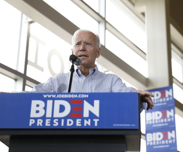 joe biden speaks at a podium displaying his campaign sign at town hall meeting, June 11, 2019, in Ottumwa, Iowa.