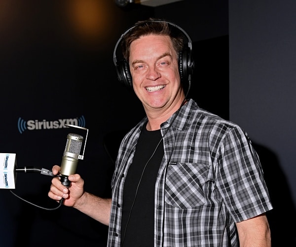 jim breuer wears headset and stands behind mic