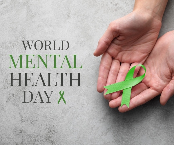 hands holding a green ribbon and the words "World Mental Health Day" in green