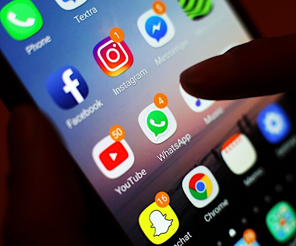 close-up of a person holding a cellphone with the apps displayed