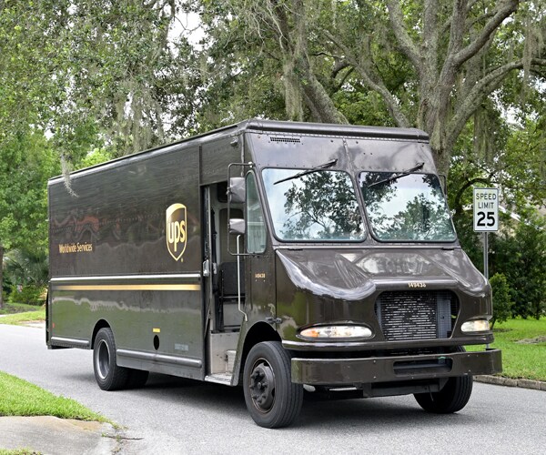 a ups truck drives through a neighborhood