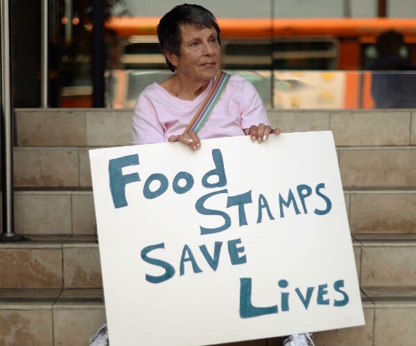 lady holding food stamp sign