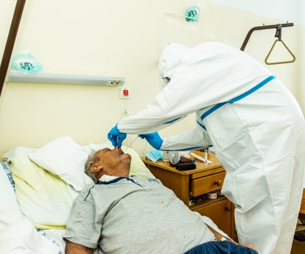 patient in hospital getting a COVID test from healthcare worker