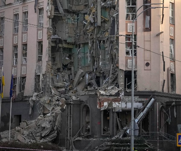 Police stand in front of damaged hotel at the scene of Russian shelling in Kyiv, Ukraine on Saturday