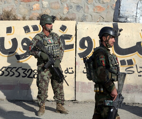 Afghan soldiers stand in front of the Kabul Military Training Center