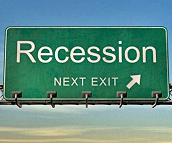 green road sign on highway with recession in capital letters next exit pointing arrow to right