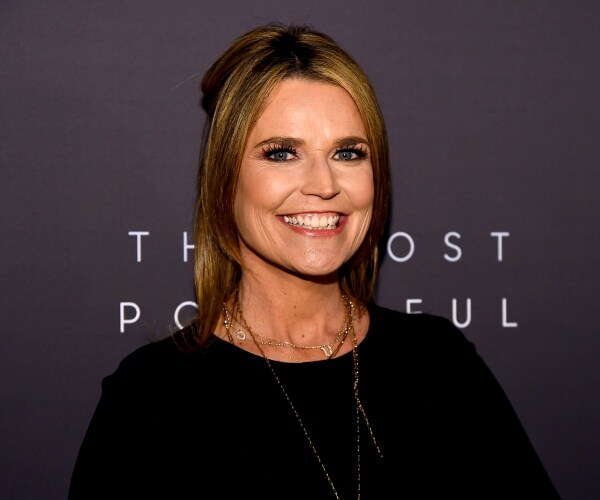 guthrie in a black top and necklace smiling