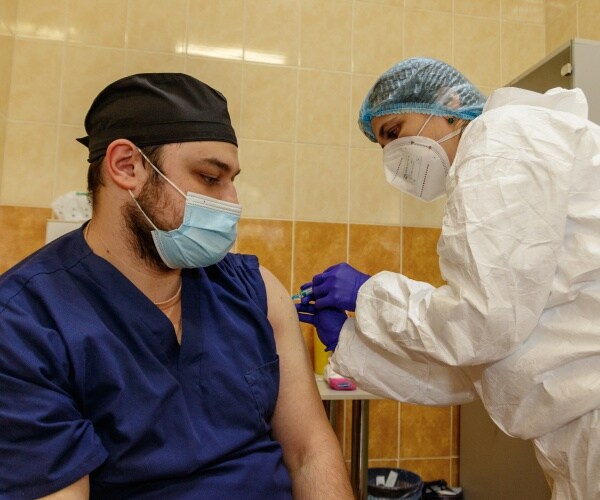 a healthcare worker getting COVID vaccine