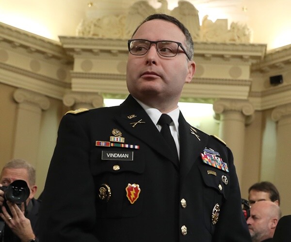 alexander vindman in full military dress stands at the table where he will testify.
