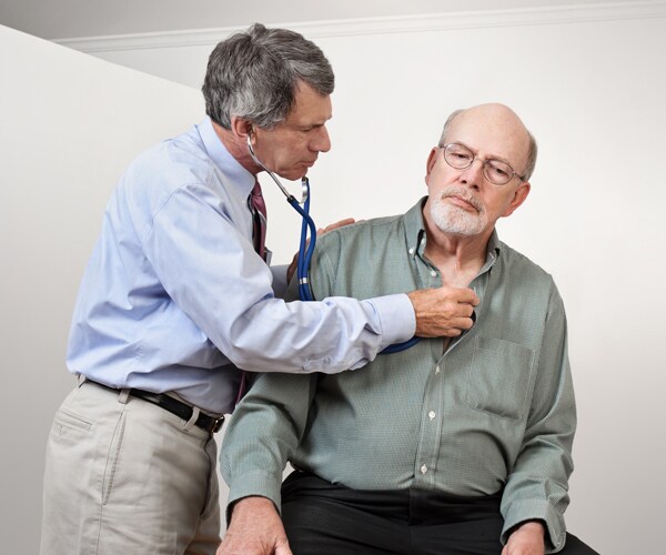 A doctor checking a man's heart