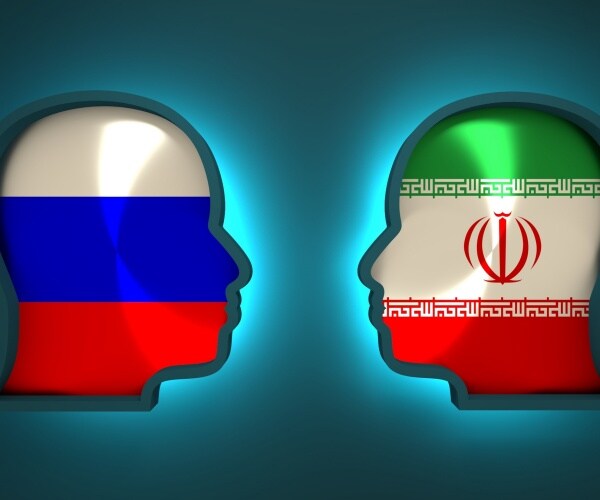 russia and iran flags inside the heads of the businessmen