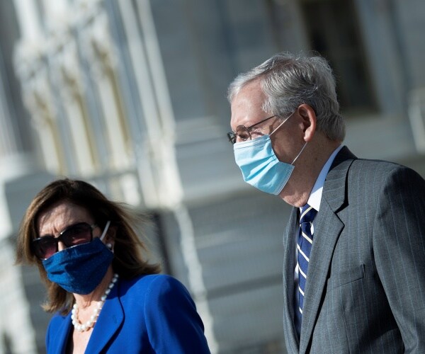 mcconnell in a gray suit wearing a blue face mask and pelosi in a blue blazer and pearl necklace with blue mask