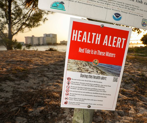 a sign warns of a red tide flare-up