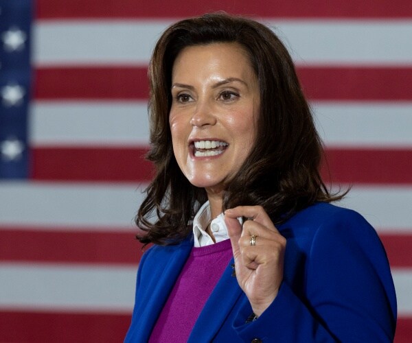 whitmer in a purple sweater and blue blazer in front of a us flag
