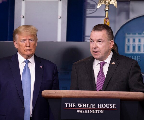 peter gaynor stands at a podium in the white house speaking about fema resources. president looks on