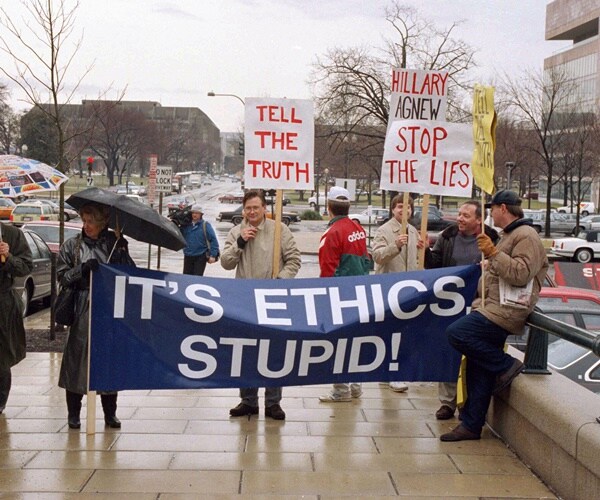 marchers hold a sign saying whitewater is about ethics in the white house