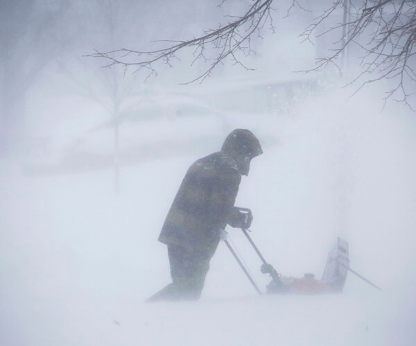 a person clears snow during a snow storm