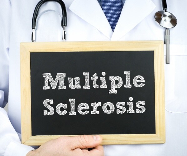 doctor holding up a chalkboard with multiple sclerosis written on it