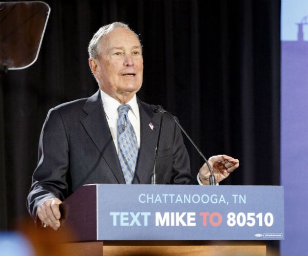 Democratic presidential candidate Mike Bloomberg speaks during a rally in suit, white dress shirt and blue tie