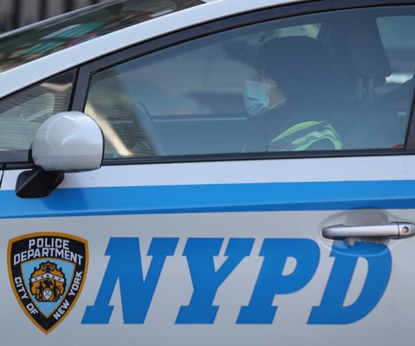  a police officer wears a face mask i their car