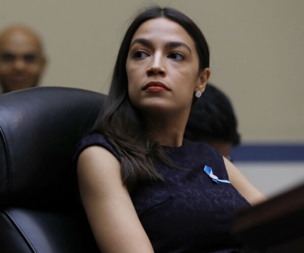 aoc listens to a colleague on capitol hill