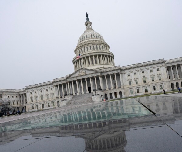 Capitol is shown from the outside and reflection on the ground