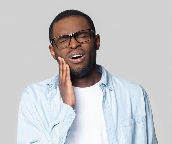 man holding jaw area of face in pain