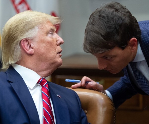 president donald trump whispers in hogan gidley's ear during a meeting at the white house