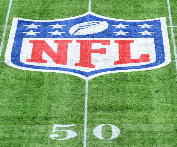 the nfl logo painted on the 50 yard line of a football field