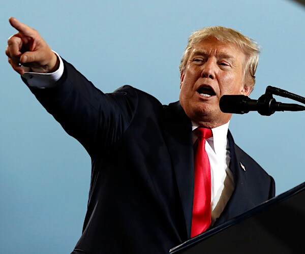 president donald trump points to his left with his left index finger, while speaking at a news conference
