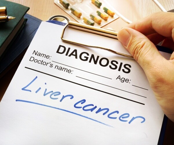 liver cancer is shown written on a diagnosis sheet on a clipboard
