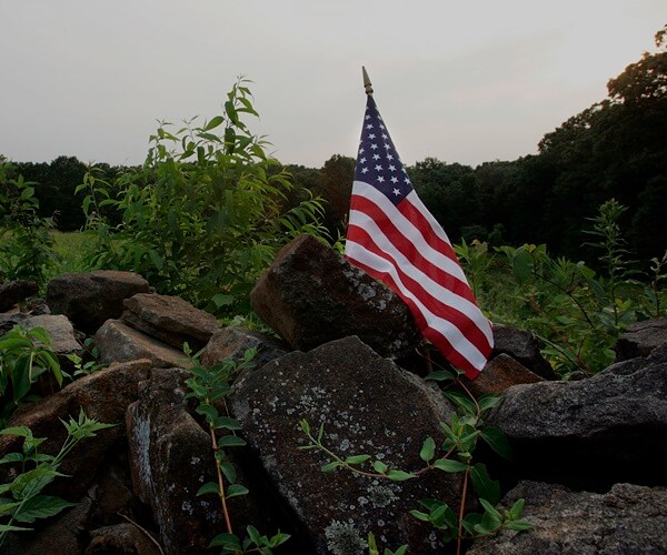 a flag is planted in a gettysburg field.