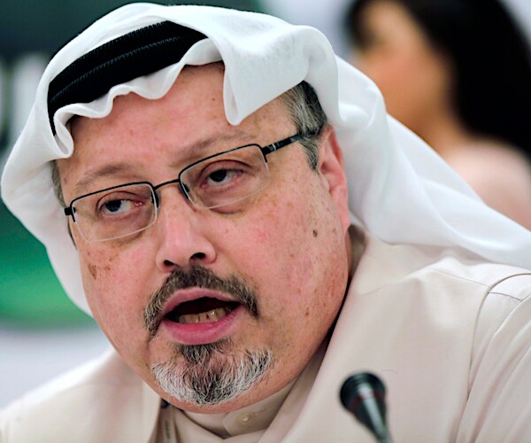 the late jamal khashoggi leans in and speaks during a forum