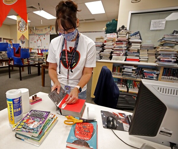 librarian disinfects books
