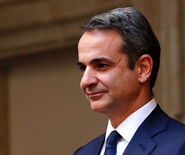 Greece Prime Minister Kyriakos Mitsotakis smirks as he arrives for a meeting