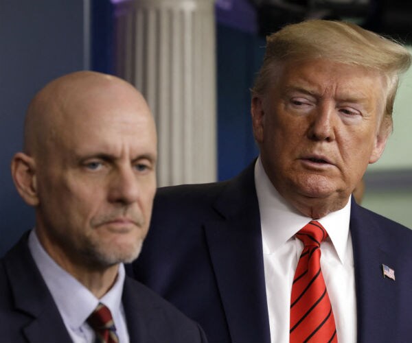 President Donald Trump listens to FDA Commissioner Stephen Hahn speaking at a press briefing 