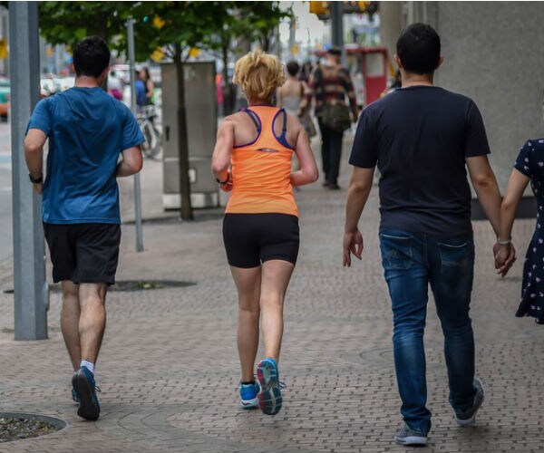 millennial runners on a city sidewalk 