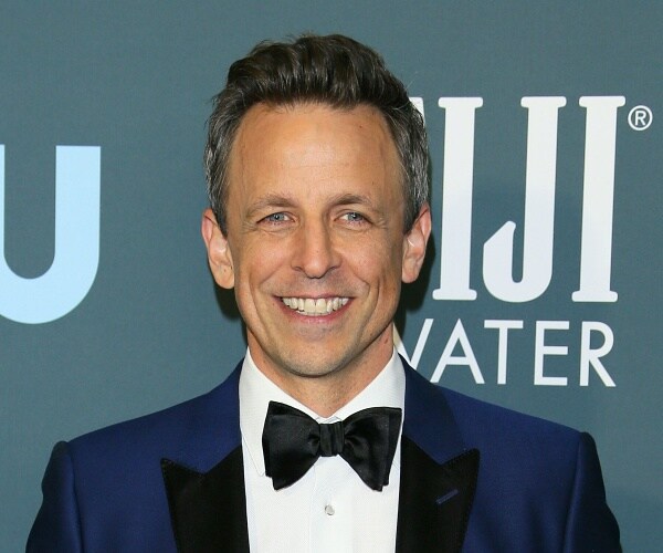 seth meyers stands on red carpet
