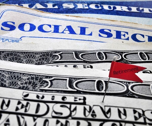 Closeup of Social Security cards and money with Retirement flag 
