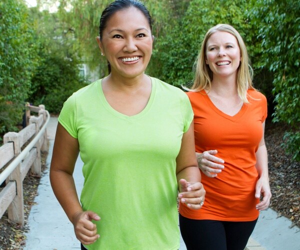 two women walking briskly outside for exercise