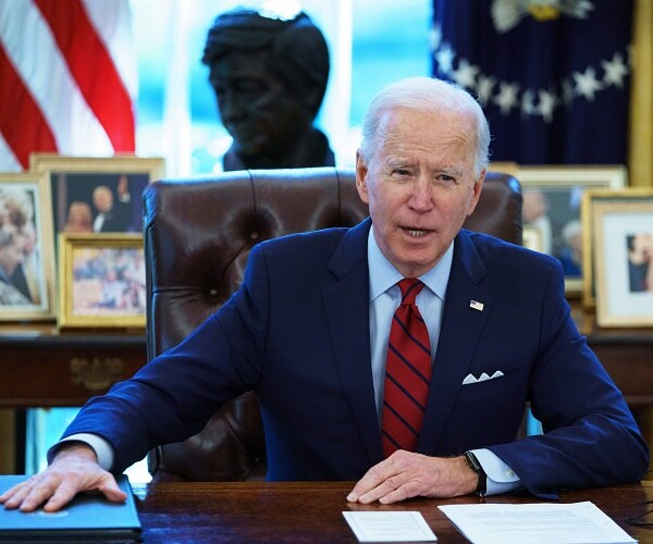 joe biden sits with hands on desk